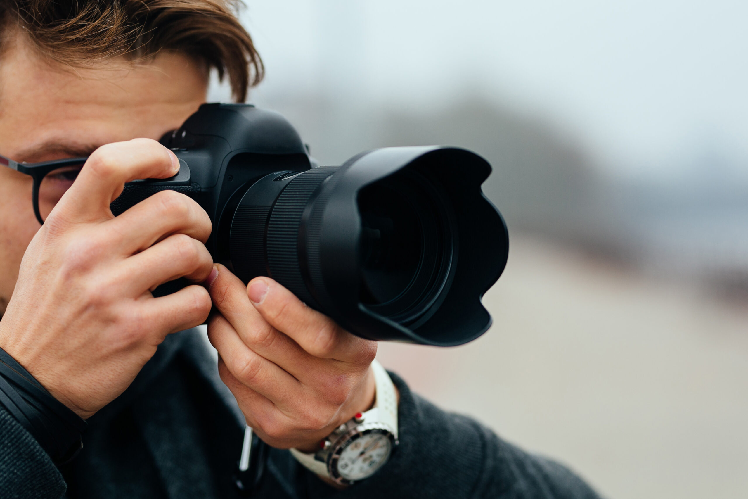Close-up view of professional photographer taking picture outdoors Close-up view of professional photographer taking picture outdoors